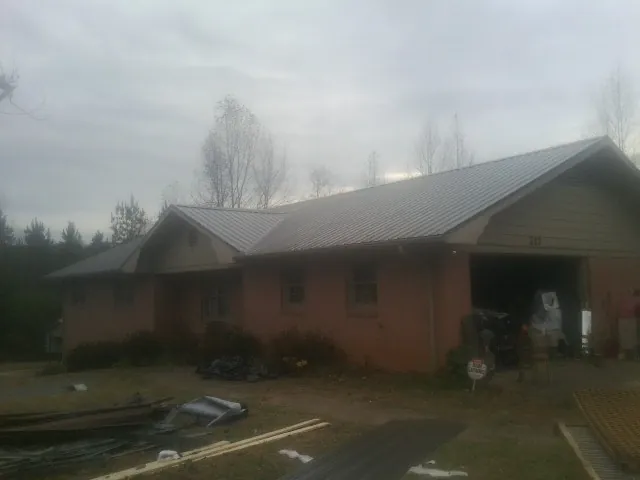 Gray metal roof on a stucco house with an attached garage in Elberta
